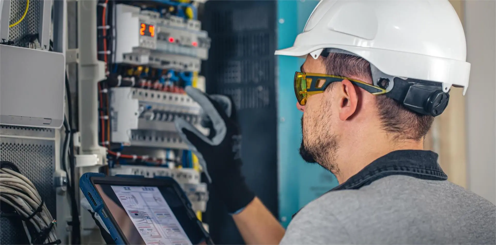 Electrician checks condition of components in distribution box